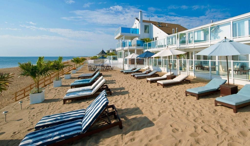 Lounge chairs on a sandy beach on a blue sky day