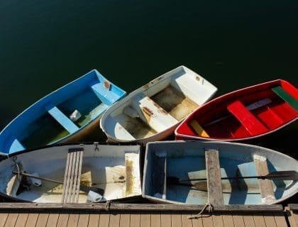 5 Small Colorful Wooden Rowboats in the Water in Rockport MA
