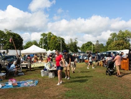 Shoppers Exploring Vendor Tented Stands Outdoors at Todd Farm Flea Market in Rowley MA