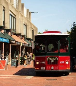 Red Vintage Trolley driving through Salem MA Downtown