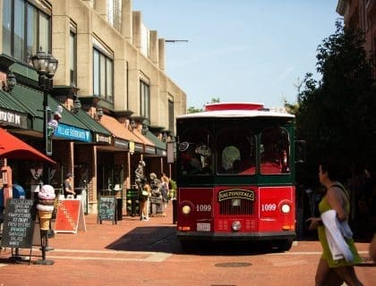 Red Vintage Trolley driving through Salem MA Downtown