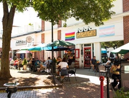 View of patrons eating under umbrellas at the outdoor tables in front of the Gulu-Gulu Cafe on a sunny day