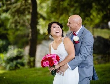 A couple happily posing with each other on their wedding day.