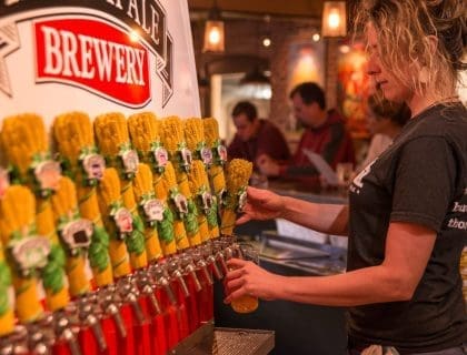A bartender poors a beer from a tap at Ipswich Brewing Company