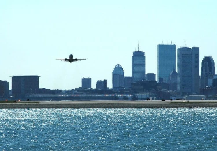 A plane taking off with Boston skyline in the background